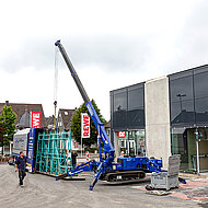 Mini-Kran unterstützt Fassadenverglasung