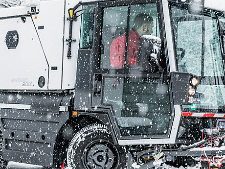 Weltweit erste Swingo Kompaktkehrmaschine mit Solespr&uuml;her und Spr&uuml;hbalken im Winterdiensteinsatz