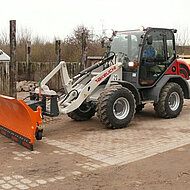 Allradgelenkter Takeuchi Radlader mit spezieller Winterausr&uuml;stung im Einsatz 