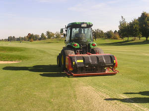 „Ein Traktor mit geringer Bodenbelastung und die Terra Spike GXi 8 von Wiedenmann erledigen das Tiefenlüften des Rasens, dessen Wert Golfprofis wie Tiger Woods zu schätzen wissen (Foto: Wiedenmann)“ 