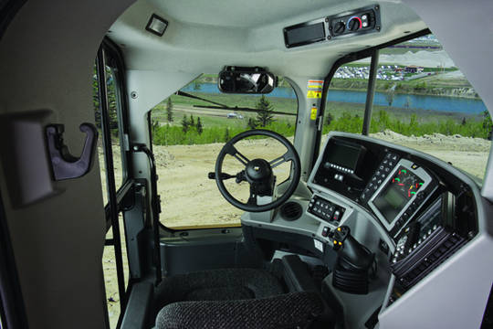 Die vergr&ouml;&szlig;erte Kabine bietet mehr Bewegungsfreiheit. Das Lenkrad wurde seitlich angeordnet und die Glasfl&auml;chen deutlich vergr&ouml;&szlig;ert, dadurch hat der Fahrer, zus&auml;tzlich durch optionale Kameras unterst&uuml;tzt, immer optimalen &Uuml;berblick.