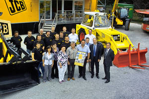 Im Bild vor dem neuen &bdquo;Sch&auml;tzchen&ldquo; (JCB Baggerlader 3C, Bj. 1965): JCB Regionalverkaufsleiter Randolf Rei&szlig;e &uuml;bergibt die JCB Gl&uuml;ckwunsche an die Gesch&auml;ftsleitung, J&uuml;rgen und Torsten Torner (Bildmitte), die sich in Begleitung von Familie und Mitarbeitern der Kamera pr&auml;sentieren.